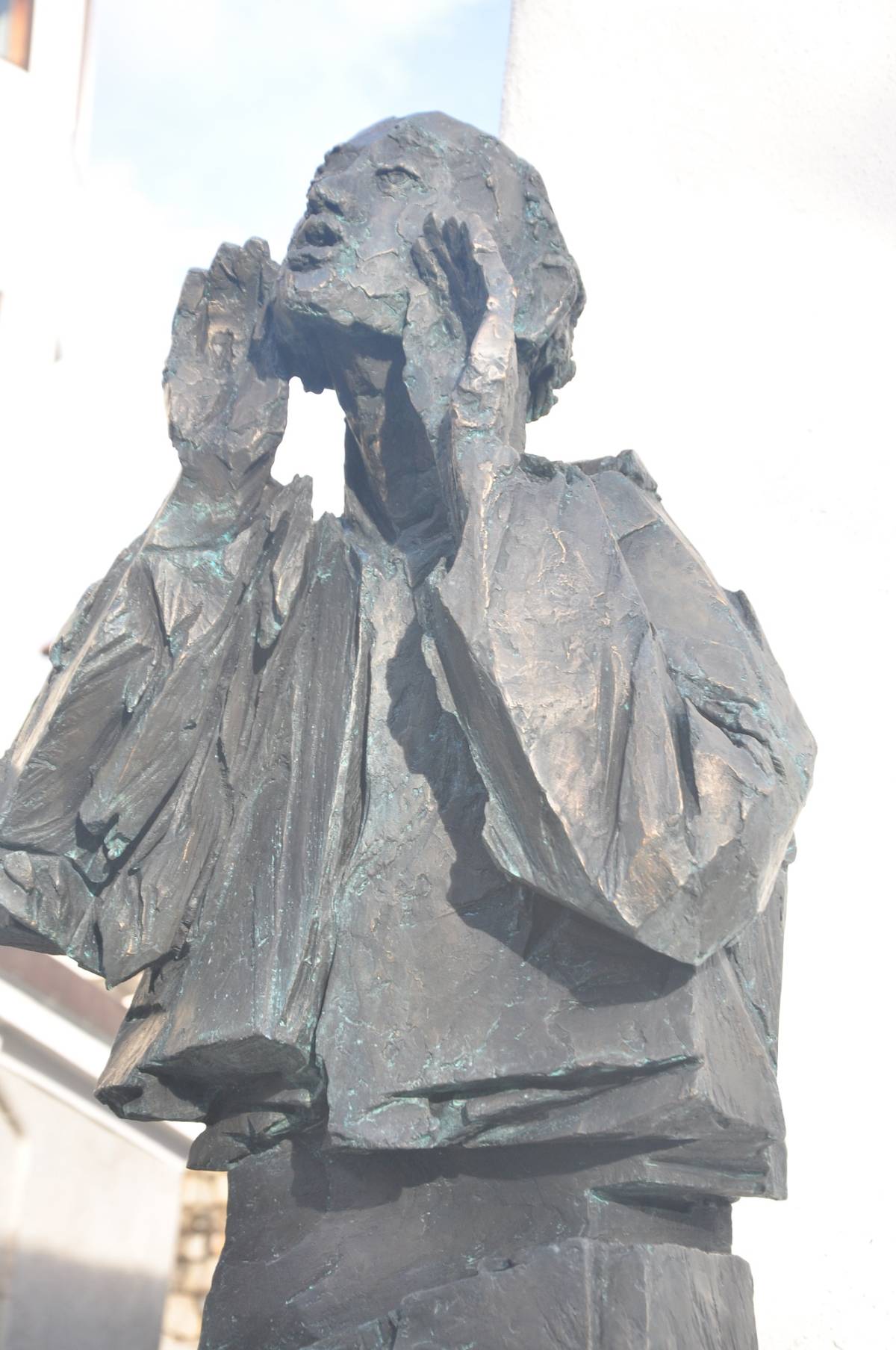 Detailaufnahme und Seitenansicht von der lebensgroße schwarzen Männerfigur, die die Hände zum Mund hält, als würde sie schreien.